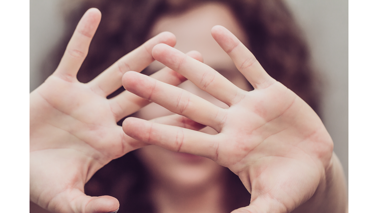 Woman makes stop gesture with two hands