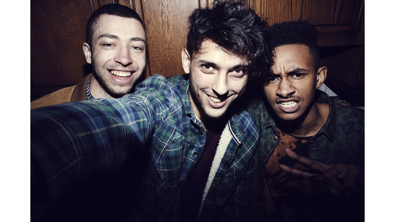 Group of friends taking selfies at a party