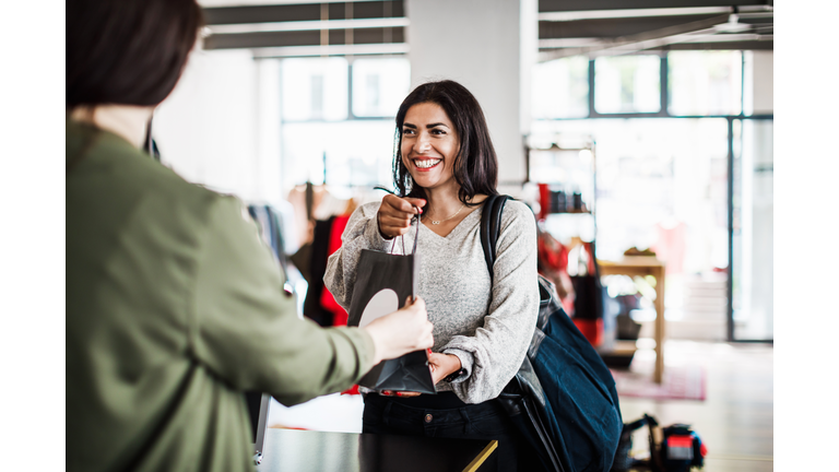 Store Clerk Handing Customer Purchased Items