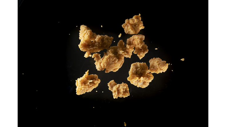 fried chicken meat flying in mid air captured with high speed sync.