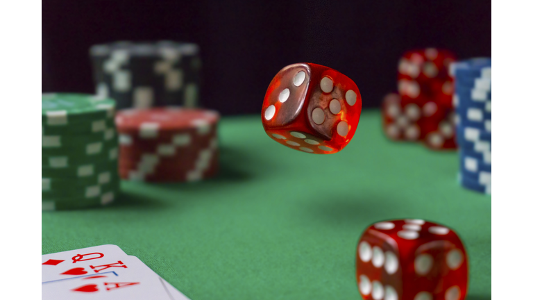 Red dice, casino chips, cards on green felt