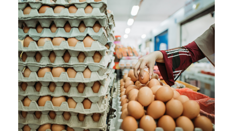 Asian malay female pick up an egg during morning market shopping