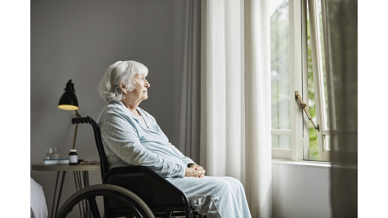 Contemplated senior female sitting on wheelchair