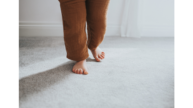 Child's taking a Step on Grey Thick Pile Carpet, casting Shadow