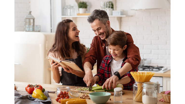 Happy family laughing loud and cooking on kitchen