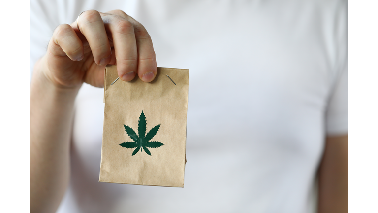 Courier hand passing package with marijuana