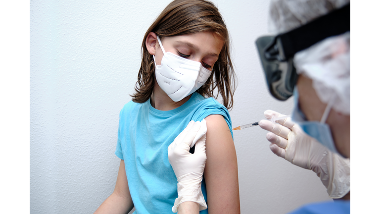 Female doctor giving covid-19 vaccine to a boy