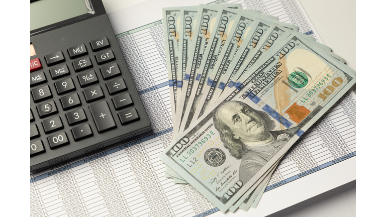 Calculator and US dollar bill banknotes on financial report