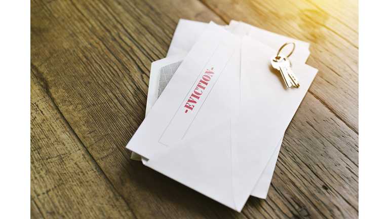 Notice of Eviction Opened in an Envelope with House Keys on a Wood Table - Sun shining through - Late Rent - Mortgage