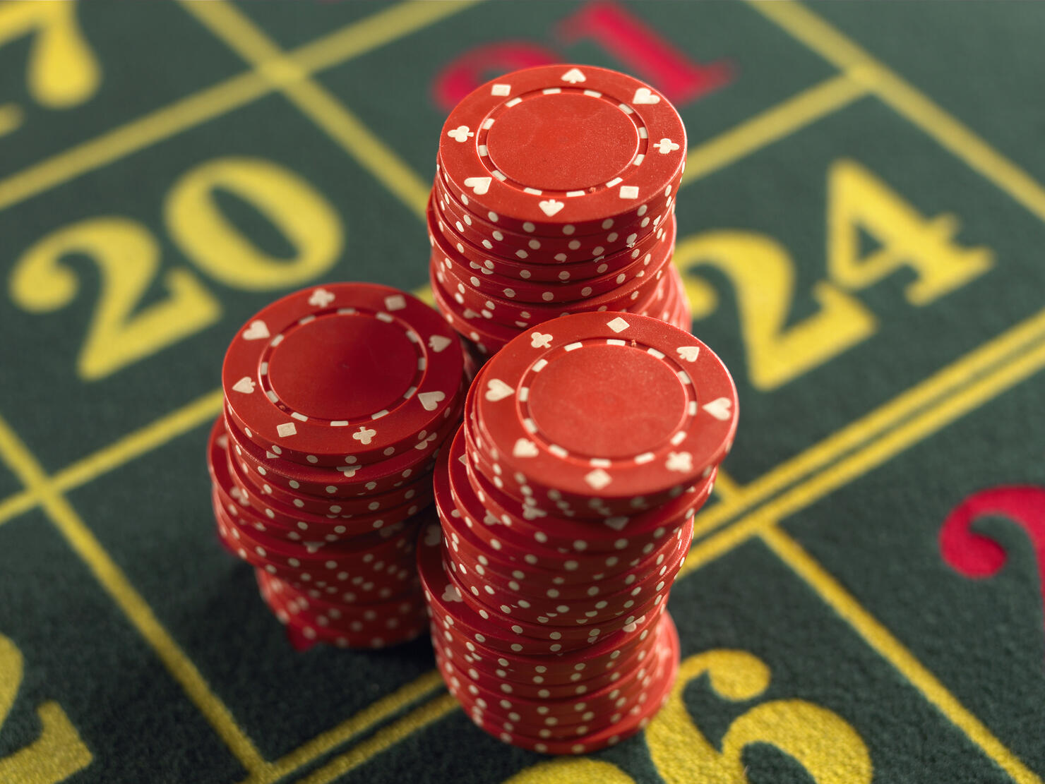 Gambling chips stacked on Roulette table in casino, close-up, elevated view