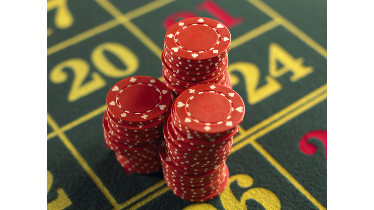 Gambling chips stacked on Roulette table in casino, close-up, elevated view