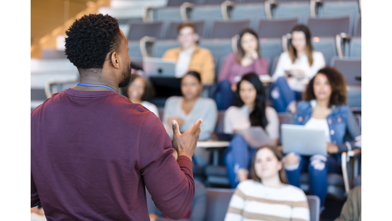 Male college professor gestures during lecture