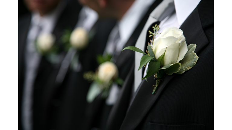 Groomsmen in black wearing white rose boutonnieres