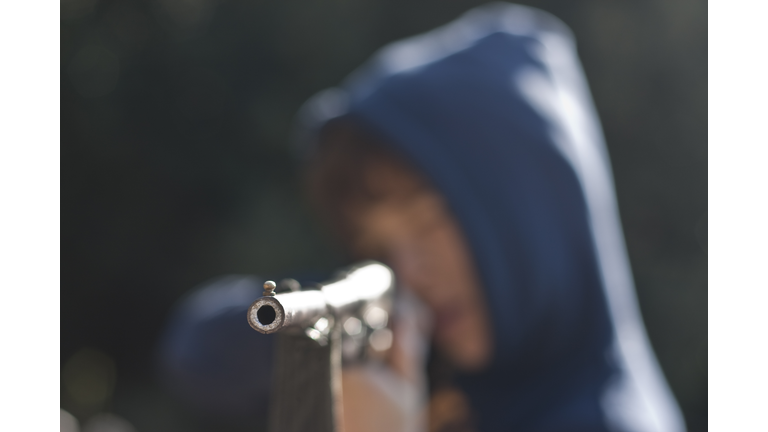 Boy with air rifle shooting