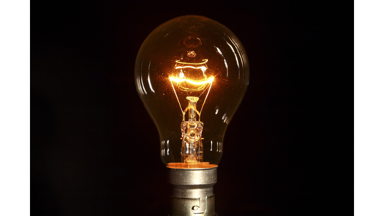 Close-Up Of Illuminated Light Bulb Against Black Background