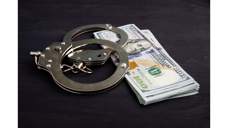 Handcuffs and money. Dollars for bail bonds.