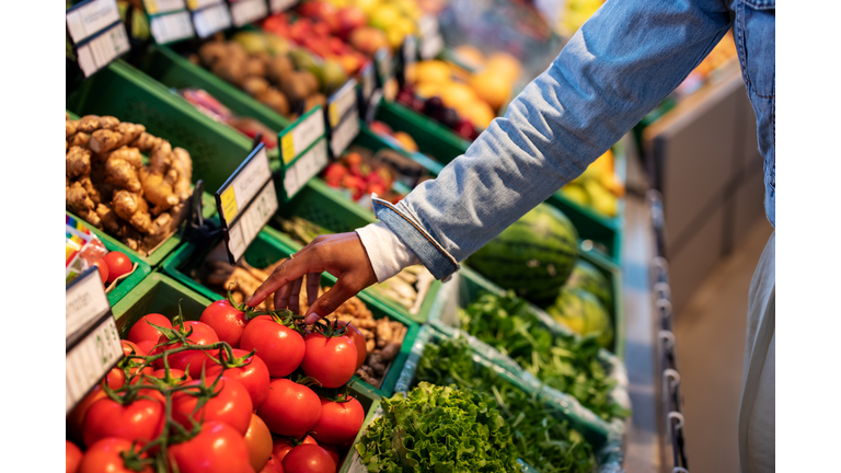 Woman buying fresh vegetables at supermarket