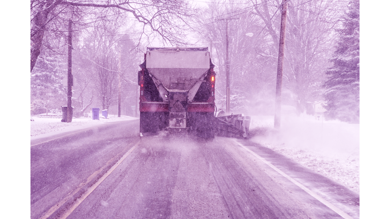 Large Municipal Snowplow Truck Plowing Snow and Spreading Road Salt