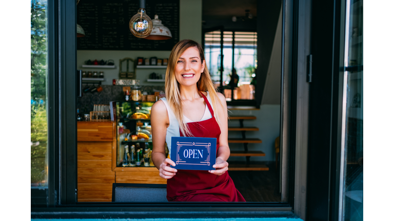 A Cheerful Small Business Owner With Open Sign
