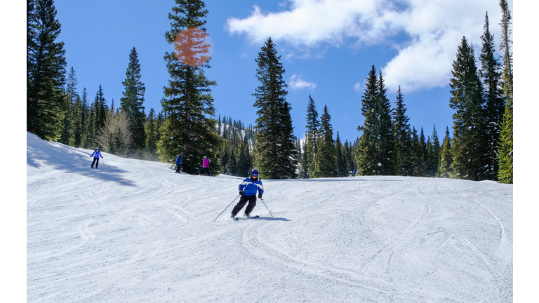 Senior downhill skier skiing in Colorado on nice winter day