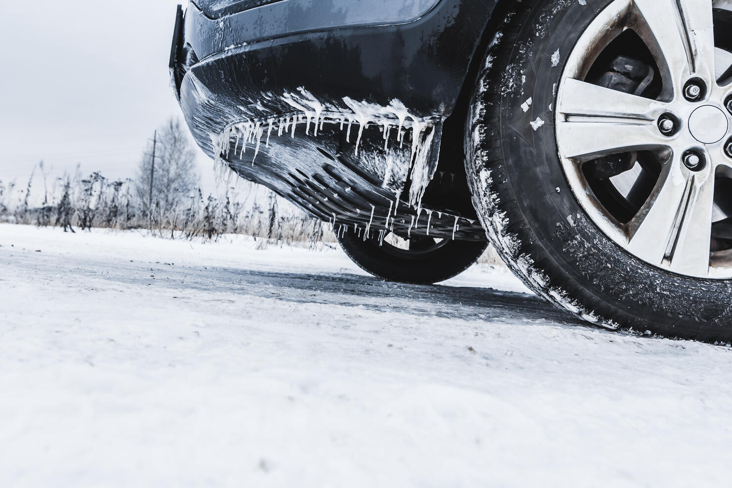 A frozen car with icicles and wheels in the snow