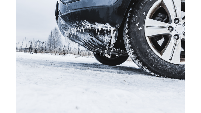 A frozen car with icicles and wheels in the snow