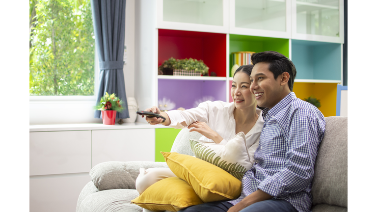 Asian couple lifestyle, man and woman watching TV movies at home, family lifestyle relax and recreation concept