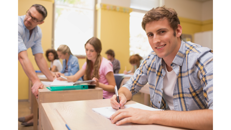 Confident student writing at desk