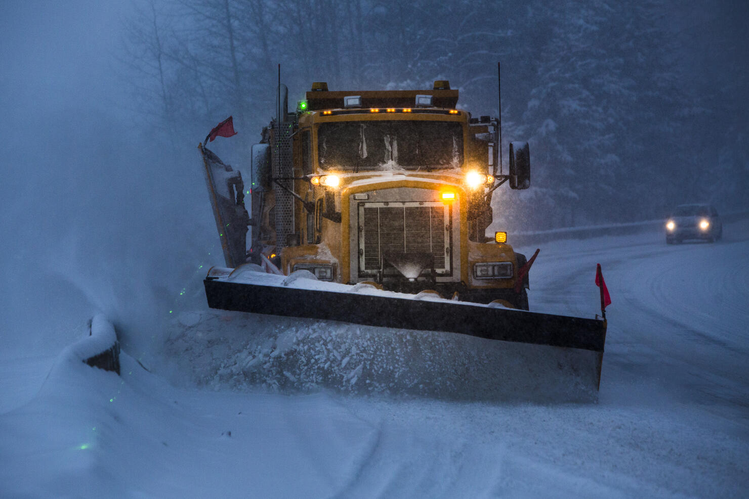 Snowplow plowing the highway during snow storm.