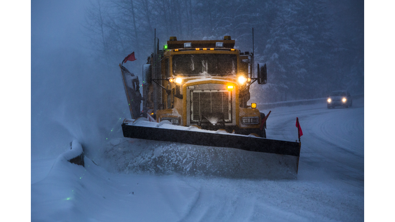 Snowplow plowing the highway during snow storm.