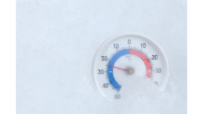 Outdoor thermometer in snow shows sub-zero temperature cold winter weather concept