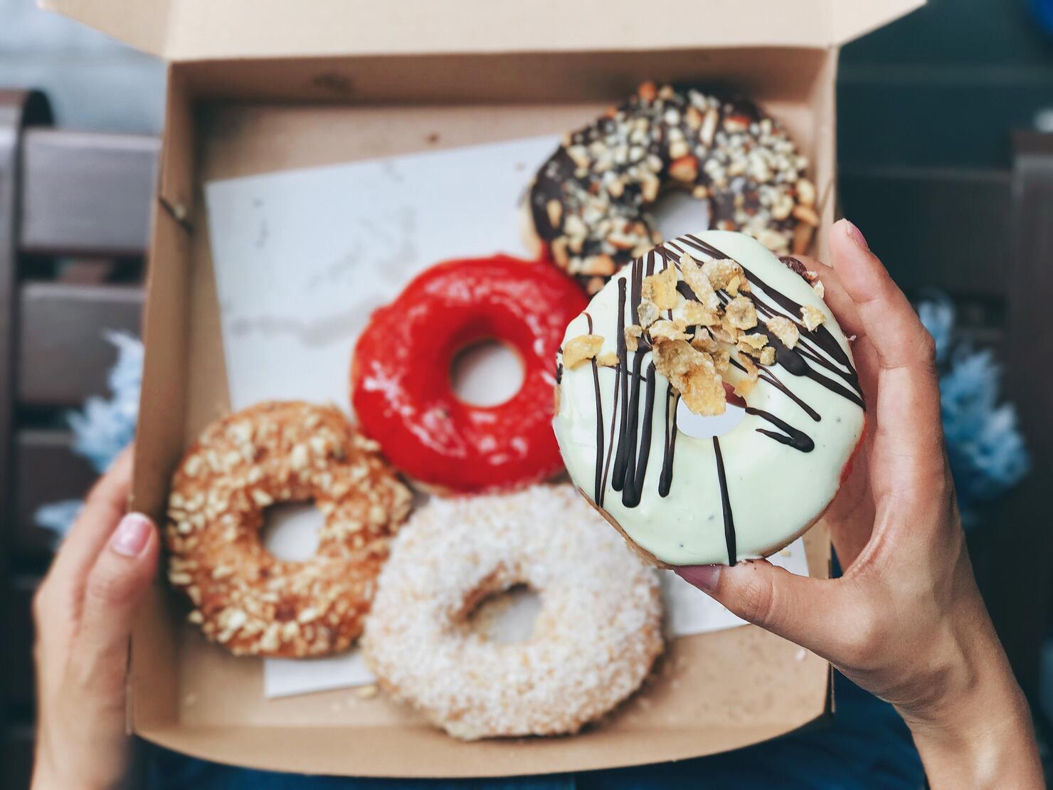 Close-Up Of Hand Holding Donut