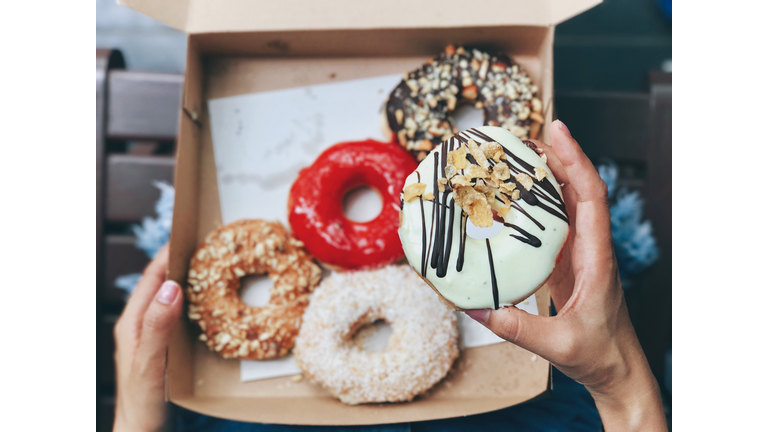 Close-Up Of Hand Holding Donut