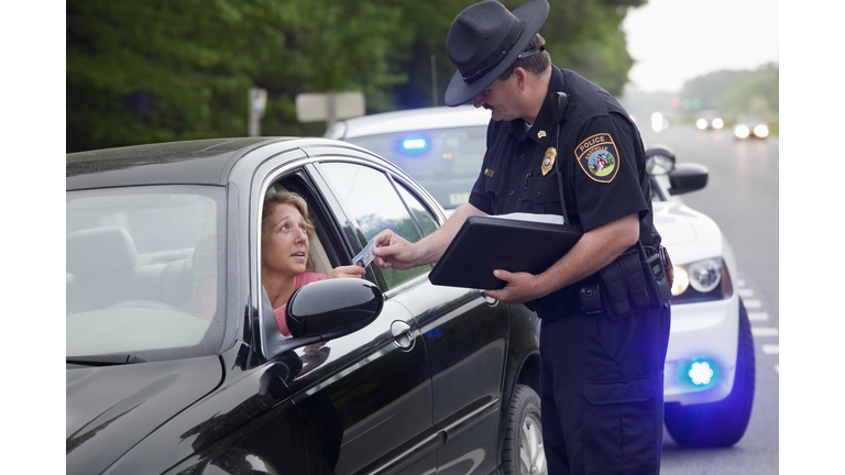 Policeman giving driver speeding ticket