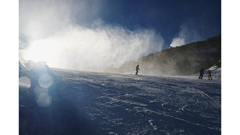 Snowmaking On Slope. Skier Near A Snow Cannon Making Fresch Powder Snow. Ski Resort And Winter