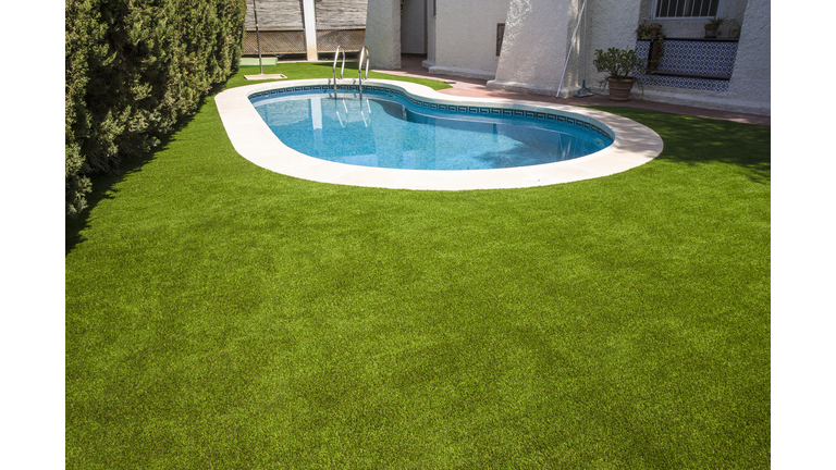 An artificial lawn around a swimming pool