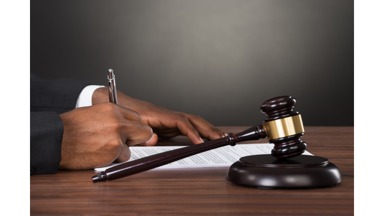 Close-up Of A Judge Writing On Paper