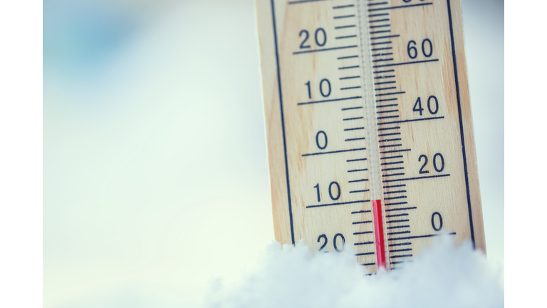 Thermometer on snow shows low temperatures under zero. Low temperatures in degrees Celsius and fahrenheit. Cold winter weather ten under zero