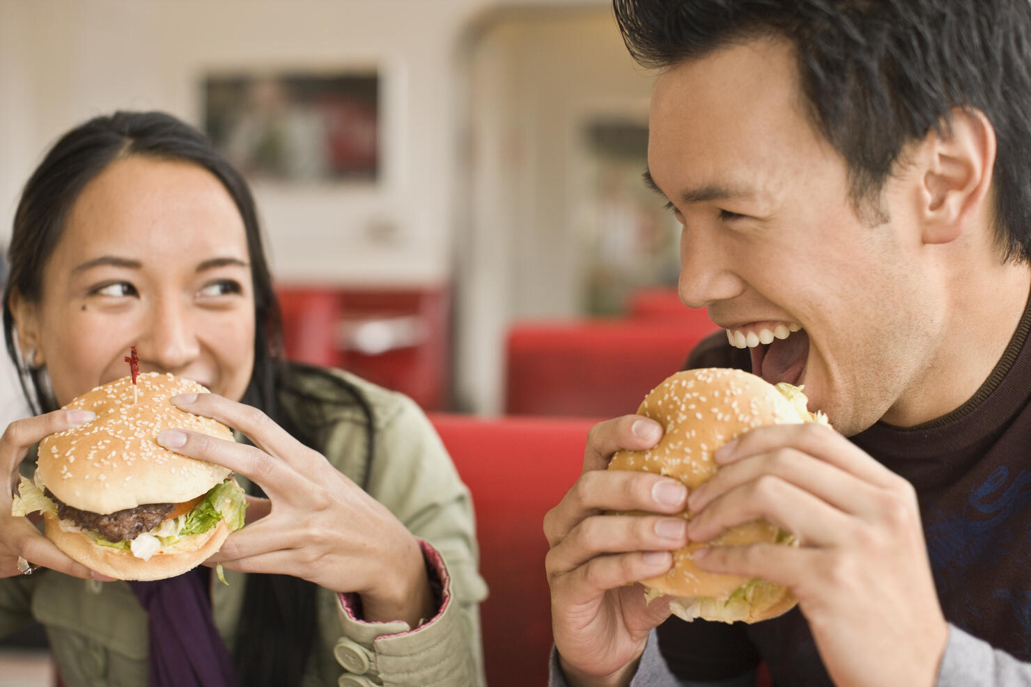 Asian couple eating hamburgers