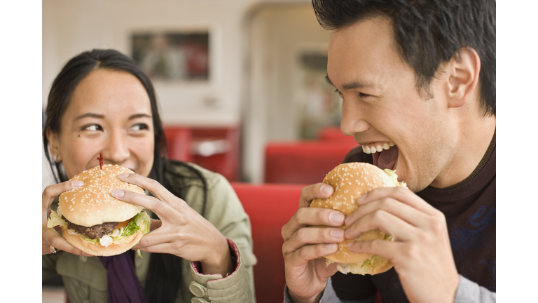 Asian couple eating hamburgers