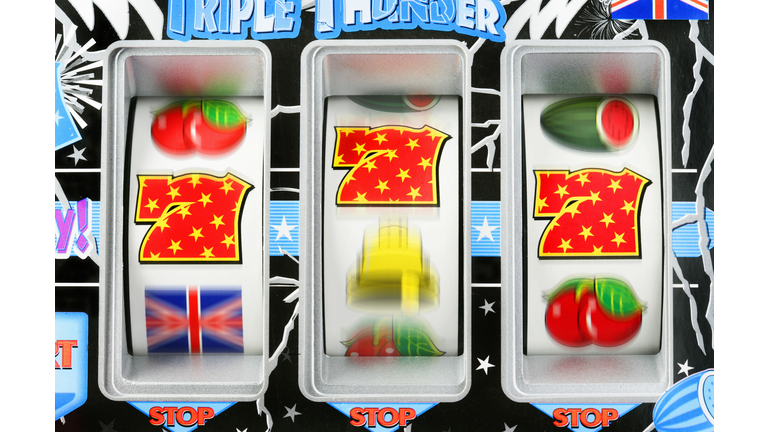 Fruit machine bars spinning to line of 7's, close-up (blurred motion)