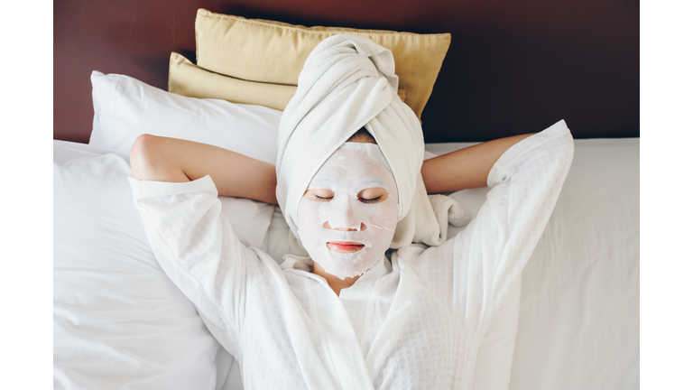 Portrait of young woman sleeping on bed with applying facial mask for enhance her skin.