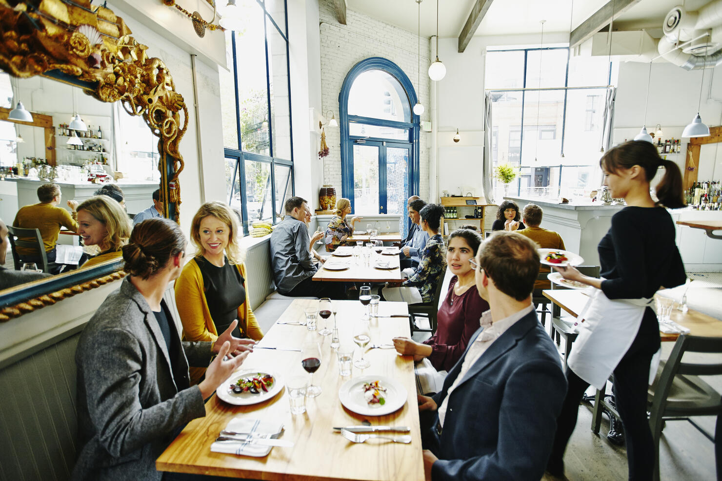 Waitress delivering food to table in restaurant