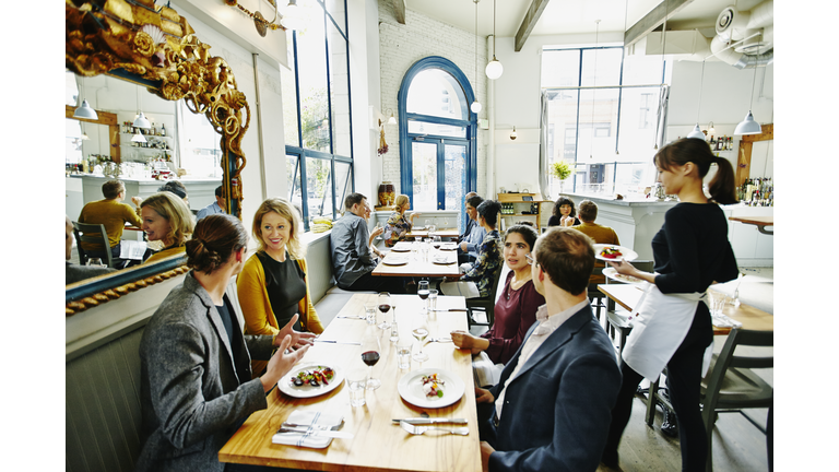 Waitress delivering food to table in restaurant