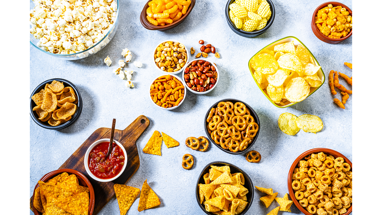 Party table with salty snacks shot from above on gray table