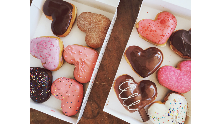 Directly Above Shot Of Colorful Heart Shaped Donuts In Boxes On Table