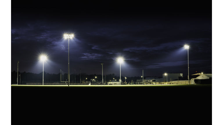 Empty small town high school football ground lighted at night