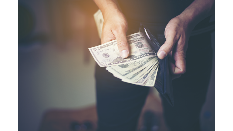 Close-Up Of Hand Removing Paper Currency From Wallet