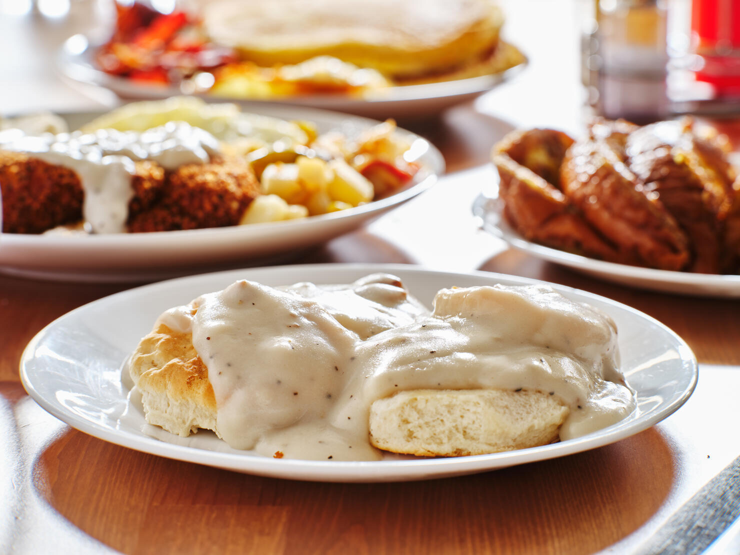 biscuits and gravy with breakfast foods on plate