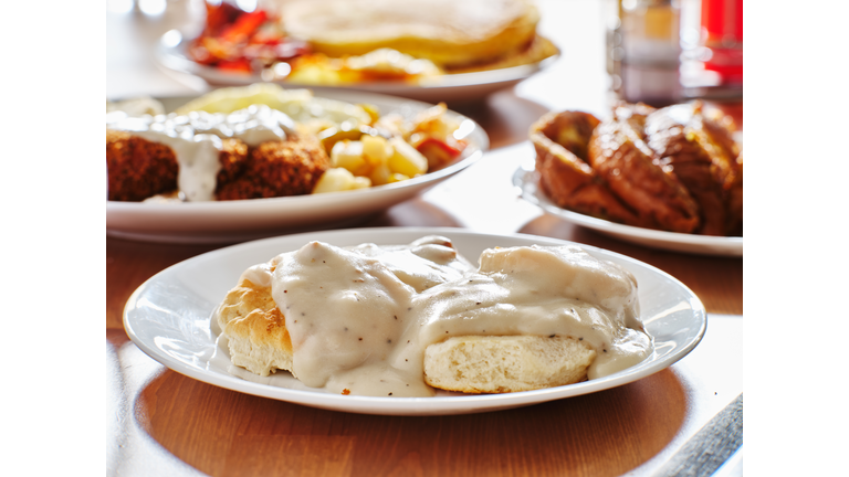 biscuits and gravy with breakfast foods on plate